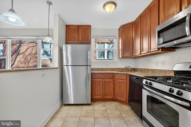 a kitchen with stainless steel appliances granite countertop a refrigerator stove and microwave