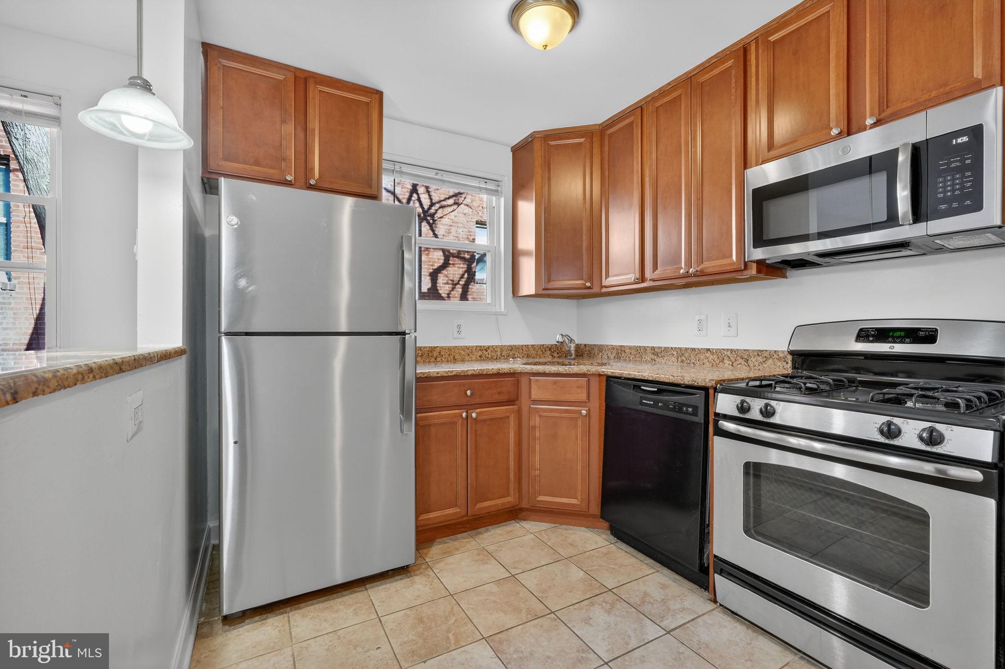 2523 13th Street Northwest, Unit 305 Washington, DC 20009 - Photo 12 of 25 a kitchen with stainless steel appliances granite countertop a refrigerator stove and microwave
