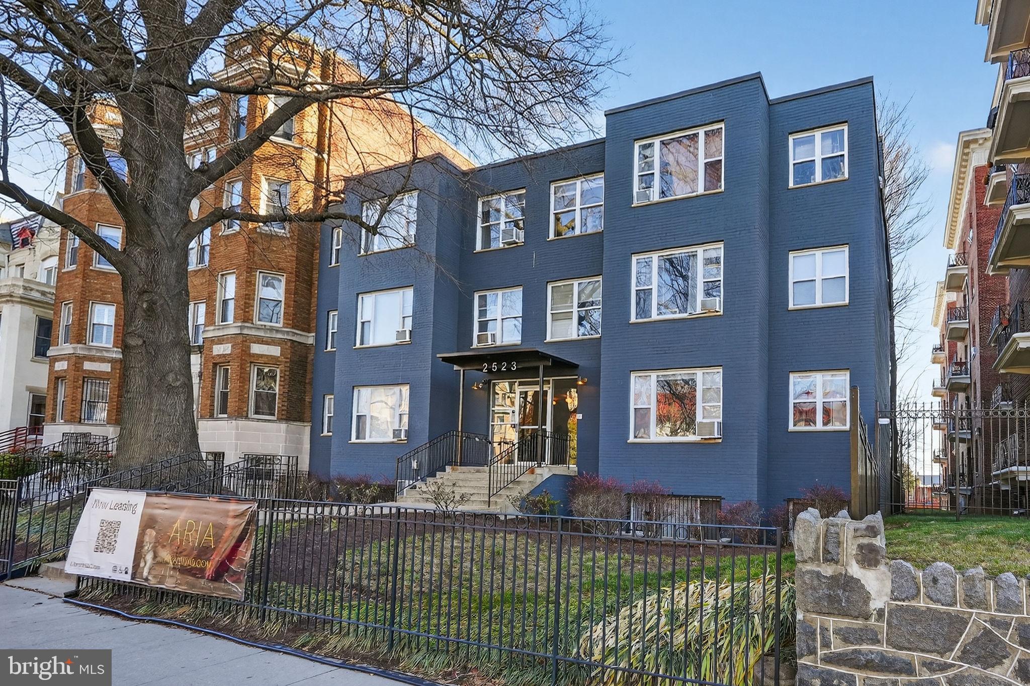 2523 13th Street Northwest, Unit 305 Washington, DC 20009 - Photo 2 of 25 a front view of a brick house with a yard