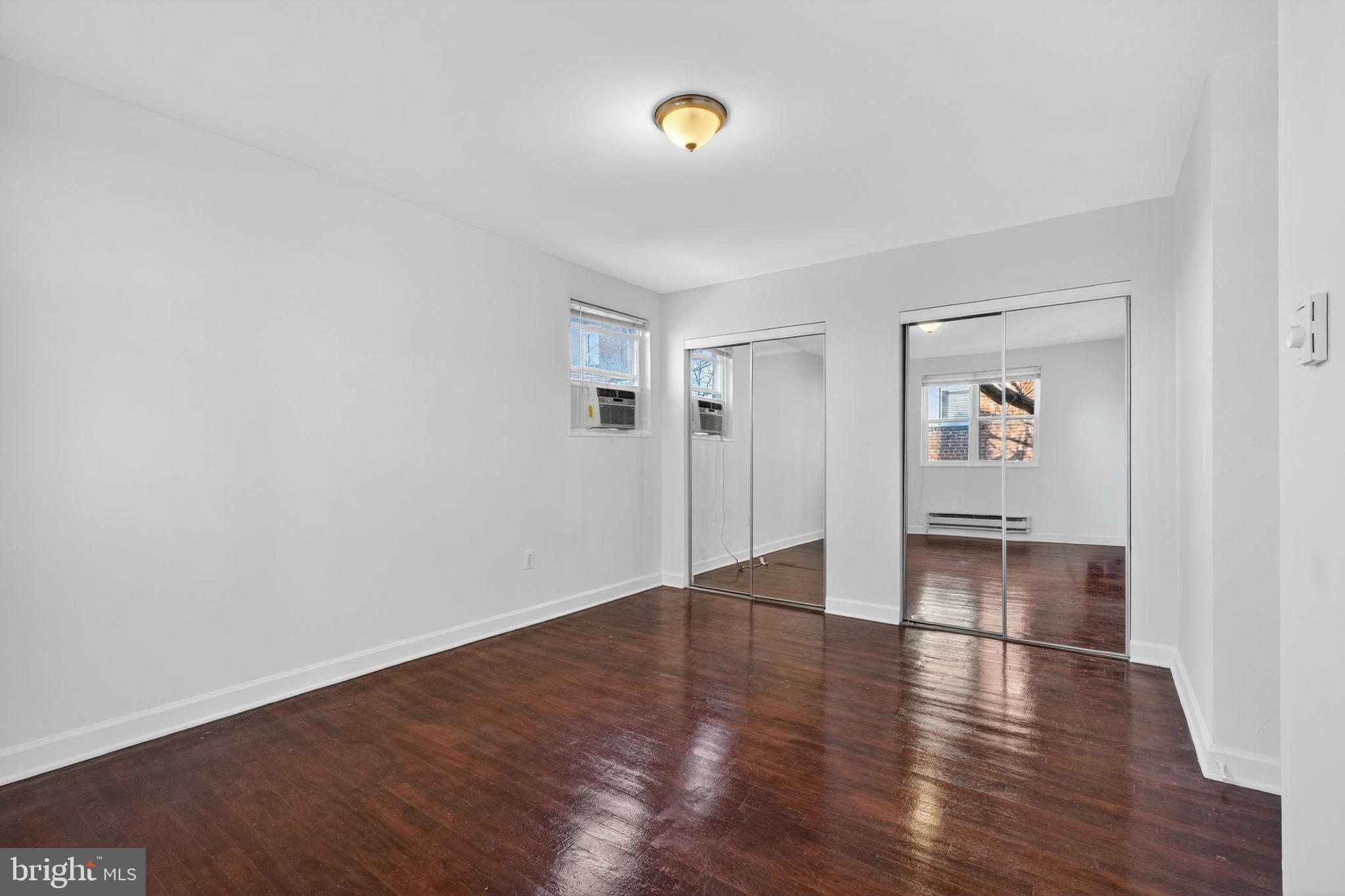 2523 13th Street Northwest, Unit 305 Washington, DC 20009 - Photo 23 of 25 an empty room with wooden floor and mirror