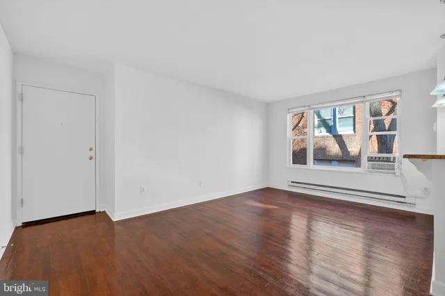 an empty room with wooden floor and door