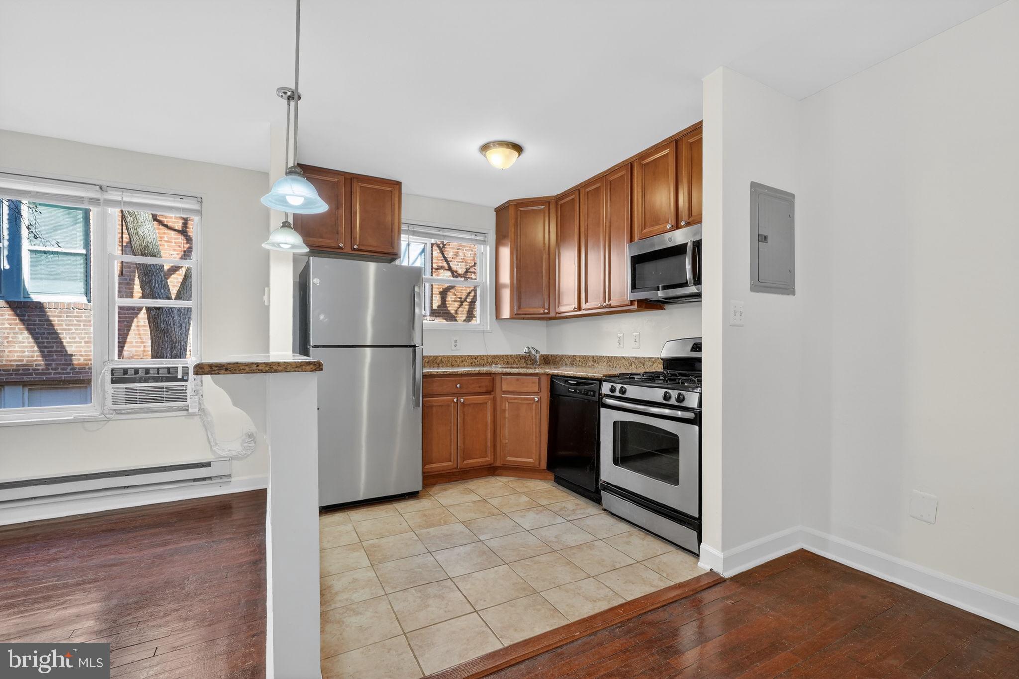 2523 13th Street Northwest, Unit 305 Washington, DC 20009 - Photo 10 of 25 a kitchen with stainless steel appliances granite countertop a refrigerator stove and sink