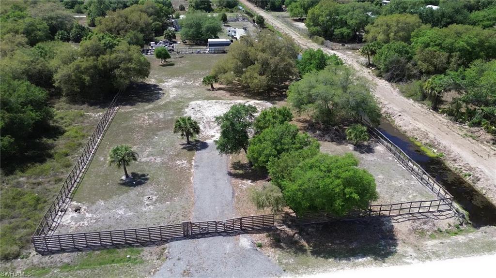 180 North Datil Street Clewiston, FL 33440 - Photo 3 of 11 an aerial view of a house with a yard and greenery