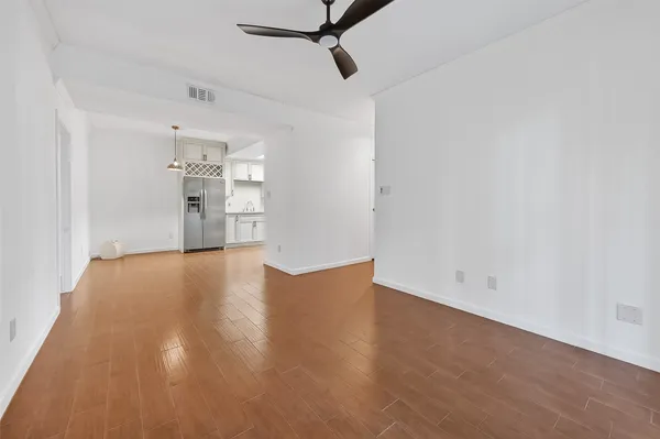 a view of empty room with wooden floor and ceiling fan