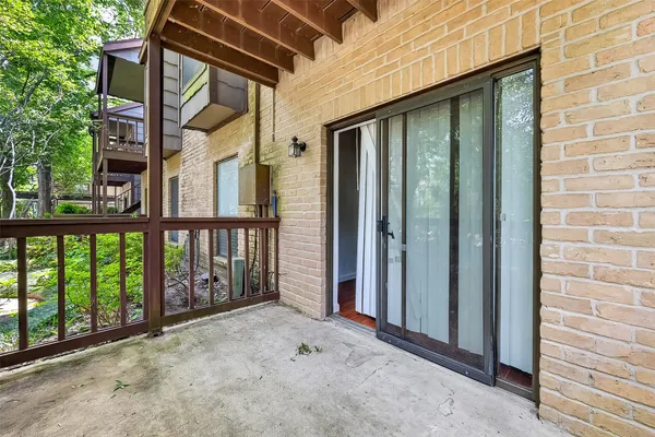 a view of a house with a floor to ceiling window and brick wall