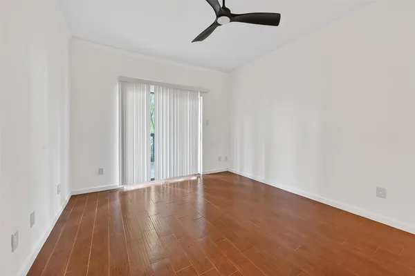 a view of an empty room with wooden floor