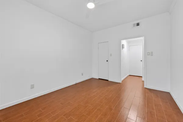 a view of a room with wooden floor and white walls