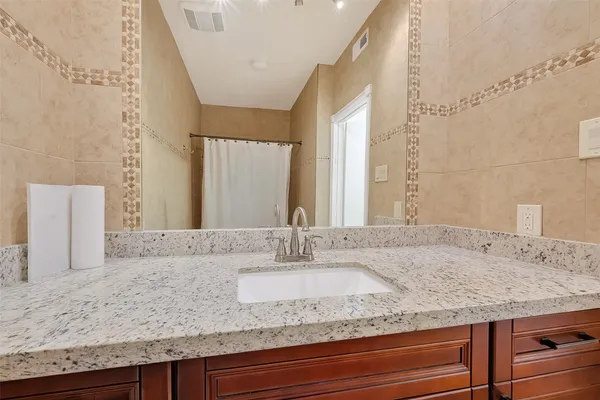 a bathroom with a granite countertop sink and a mirror