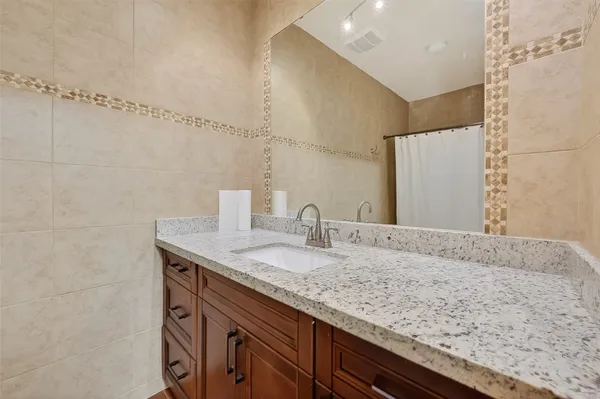 a bathroom with a granite countertop sink and a mirror