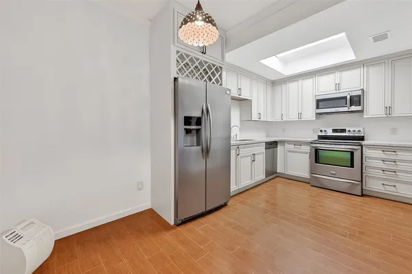 a kitchen with stainless steel appliances a stove a sink and a refrigerator