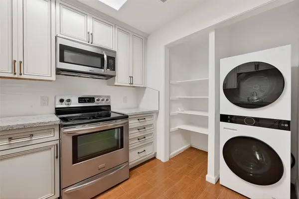 a kitchen with a stove and a washer dryer