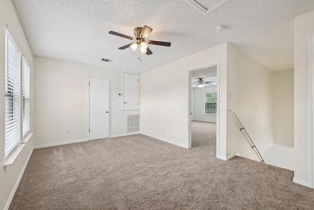 a view of an empty room with closet and a window