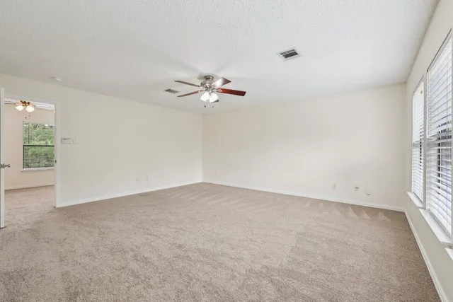 an empty room with a window and a ceiling fan