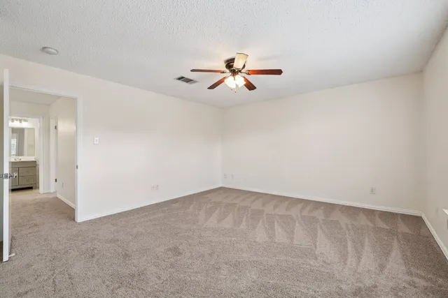 a view of a room with a ceiling fan and a window