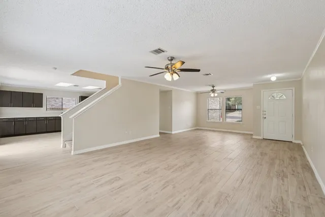 a view of a livingroom with wooden floor and staircase