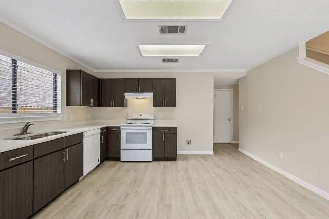 a kitchen with stainless steel appliances a sink dishwasher stove and refrigerator