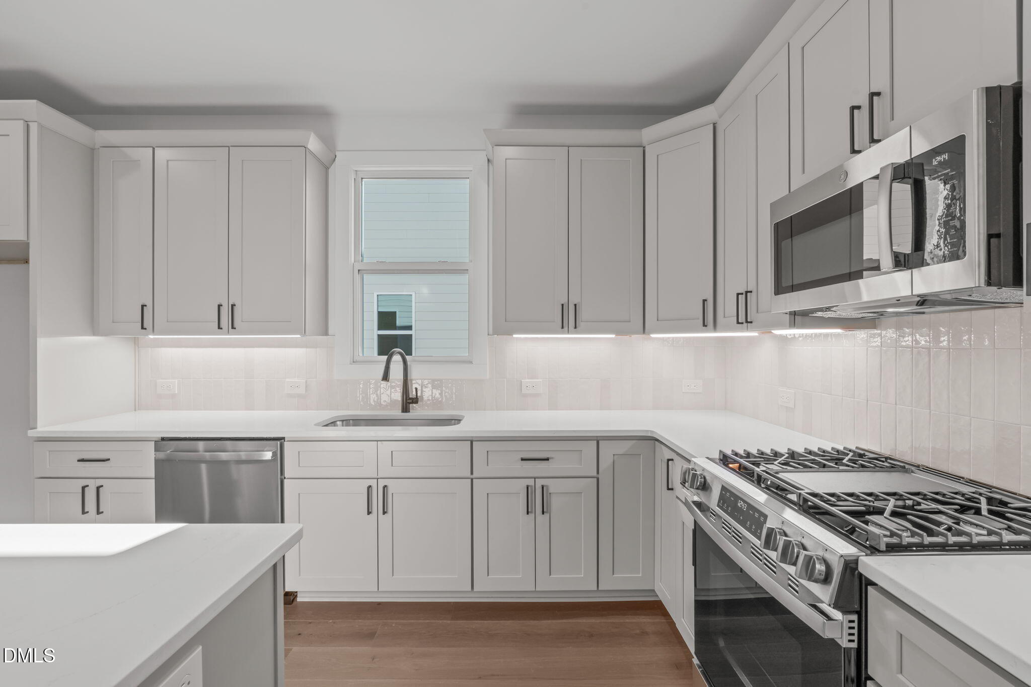637 Conover Road, Unit B Durham, NC 27703 - Photo 18 of 52 a kitchen with stainless steel appliances granite countertop a sink stove oven and white cabinets