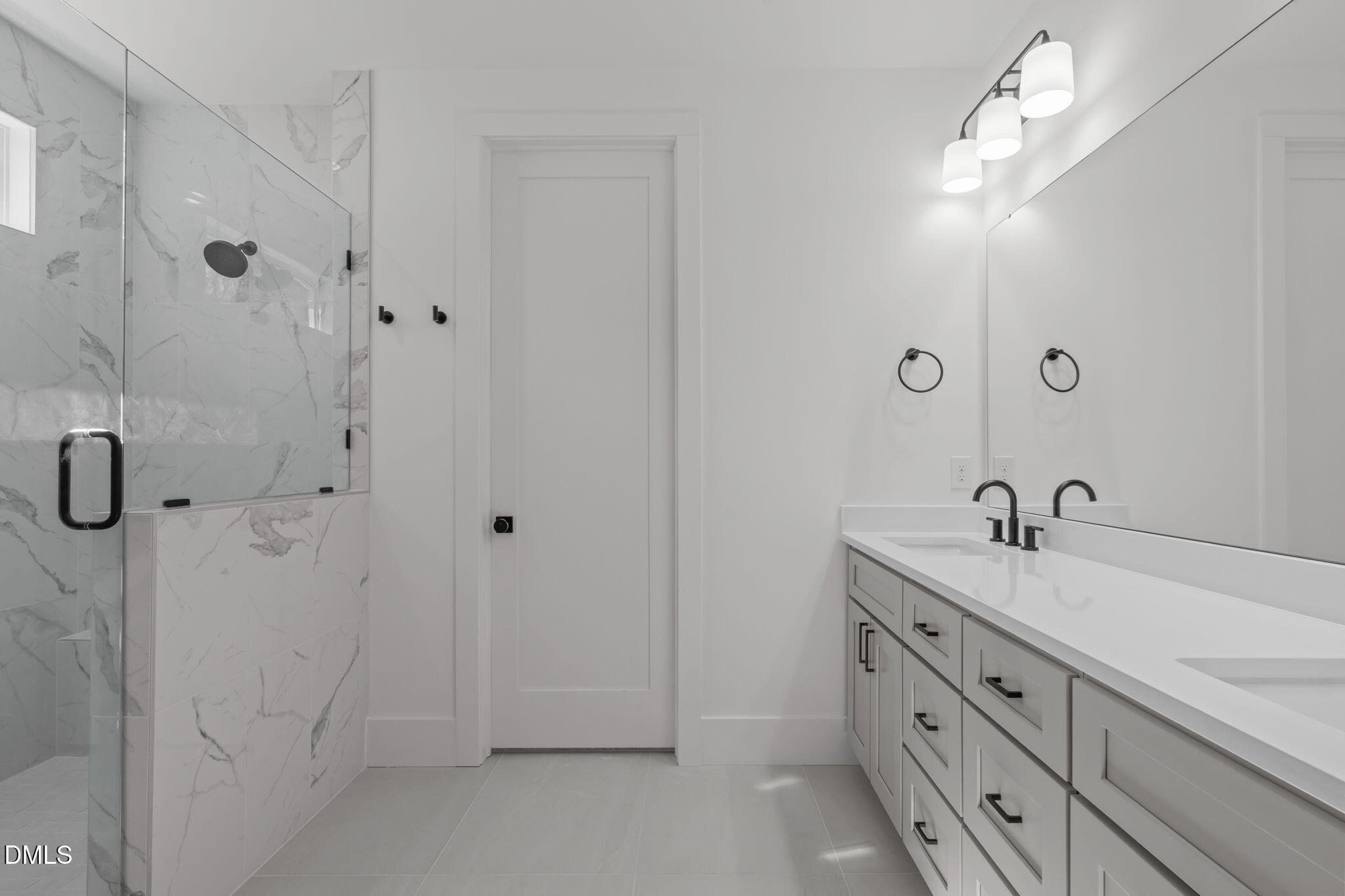 637 Conover Road, Unit B Durham, NC 27703 - Photo 4 of 52 a bathroom with a double vanity sink a large mirror and shower