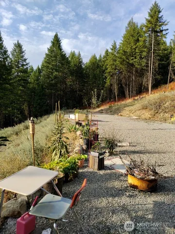 a view of a backyard with table and chairs couches under an umbrella
