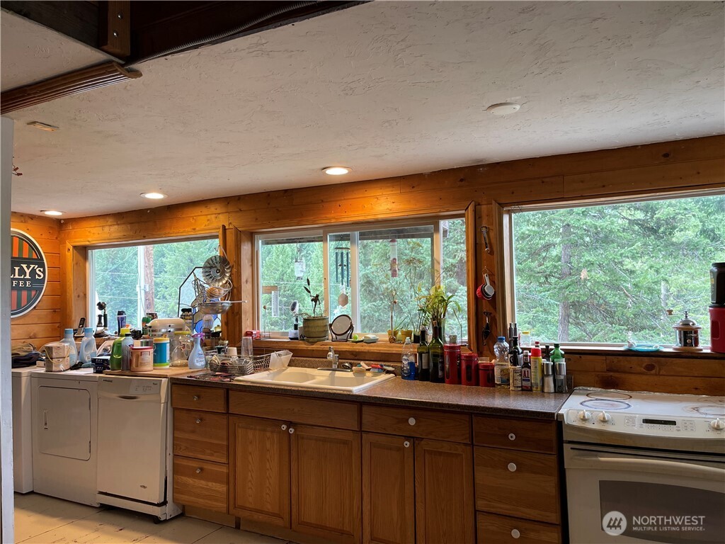 57 Slippery Hill Lane Republic, WA 99166 - Photo 4 of 32 a kitchen with sink a large window and cabinets