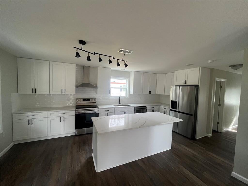 151 Richardson Street Toccoa, GA 30577 - Photo 13 of 48 a large kitchen with a center island wooden floor stainless steel appliances and cabinets