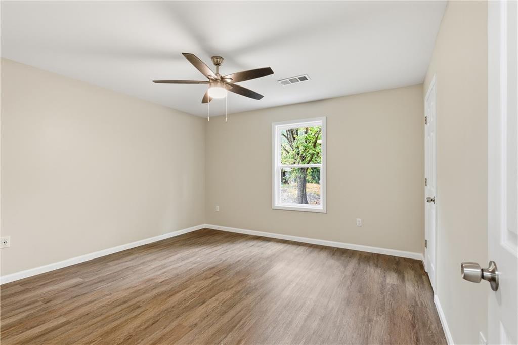 151 Richardson Street Toccoa, GA 30577 - Photo 29 of 48 an empty room with wooden floor fan and windows
