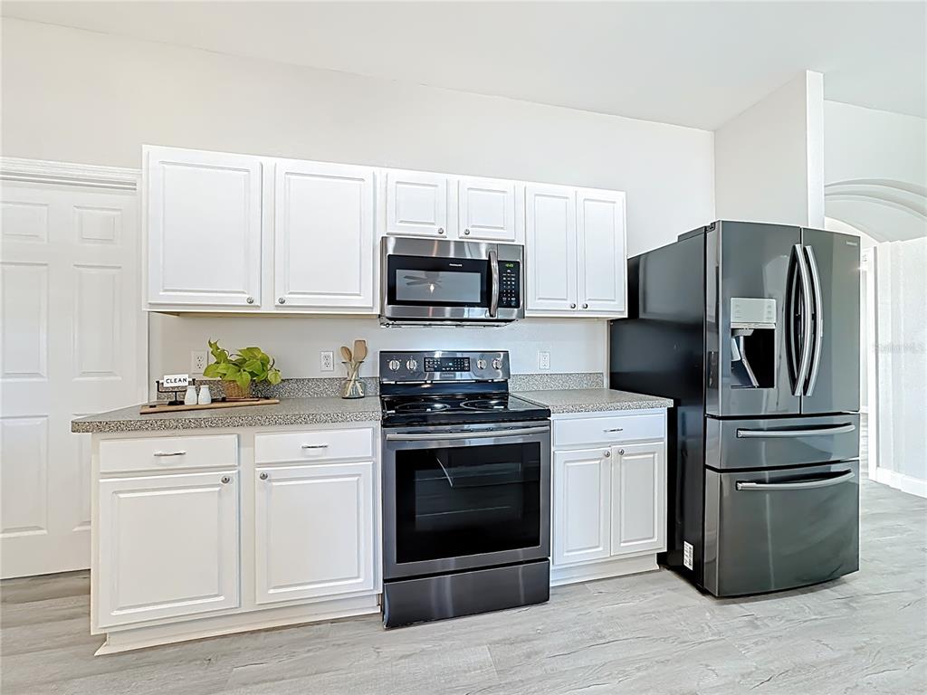 312 Towhee Road Winter Haven, FL 33881 - Photo 12 of 45 a kitchen with cabinets stainless steel appliances and wooden floor