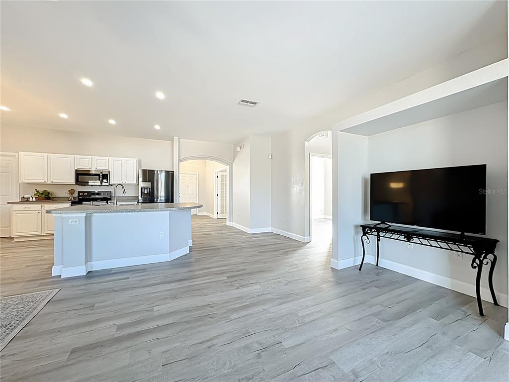312 Towhee Road Winter Haven, FL 33881 - Photo 16 of 45 a view of kitchen with microwave a refrigerator and a stove top oven with wooden floor