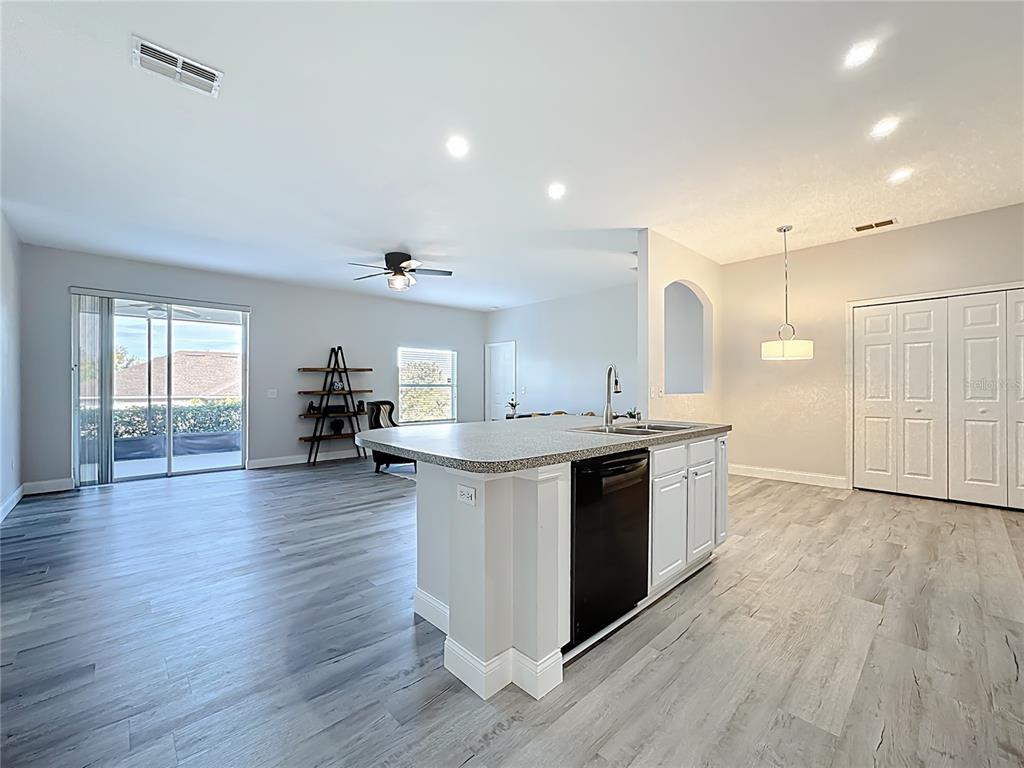 312 Towhee Road Winter Haven, FL 33881 - Photo 17 of 45 a kitchen with kitchen island granite countertop a sink cabinets and wooden floor