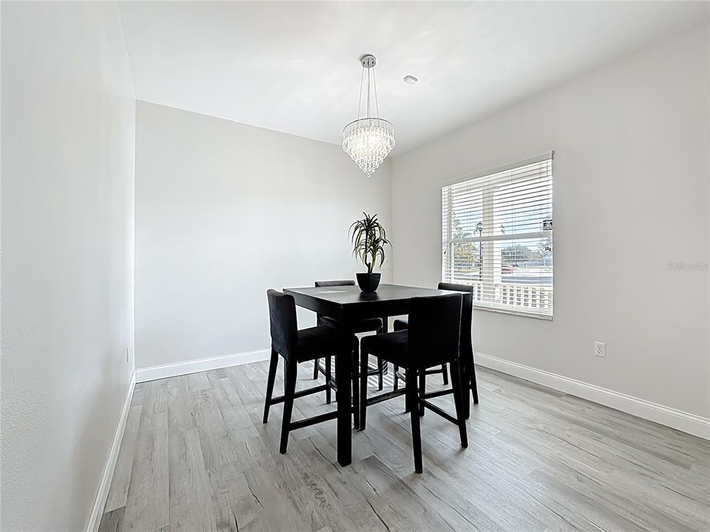 312 Towhee Road Winter Haven, FL 33881 - Photo 20 of 45 a view of a dining room with wooden floor a chandelier a wooden table and chairs
