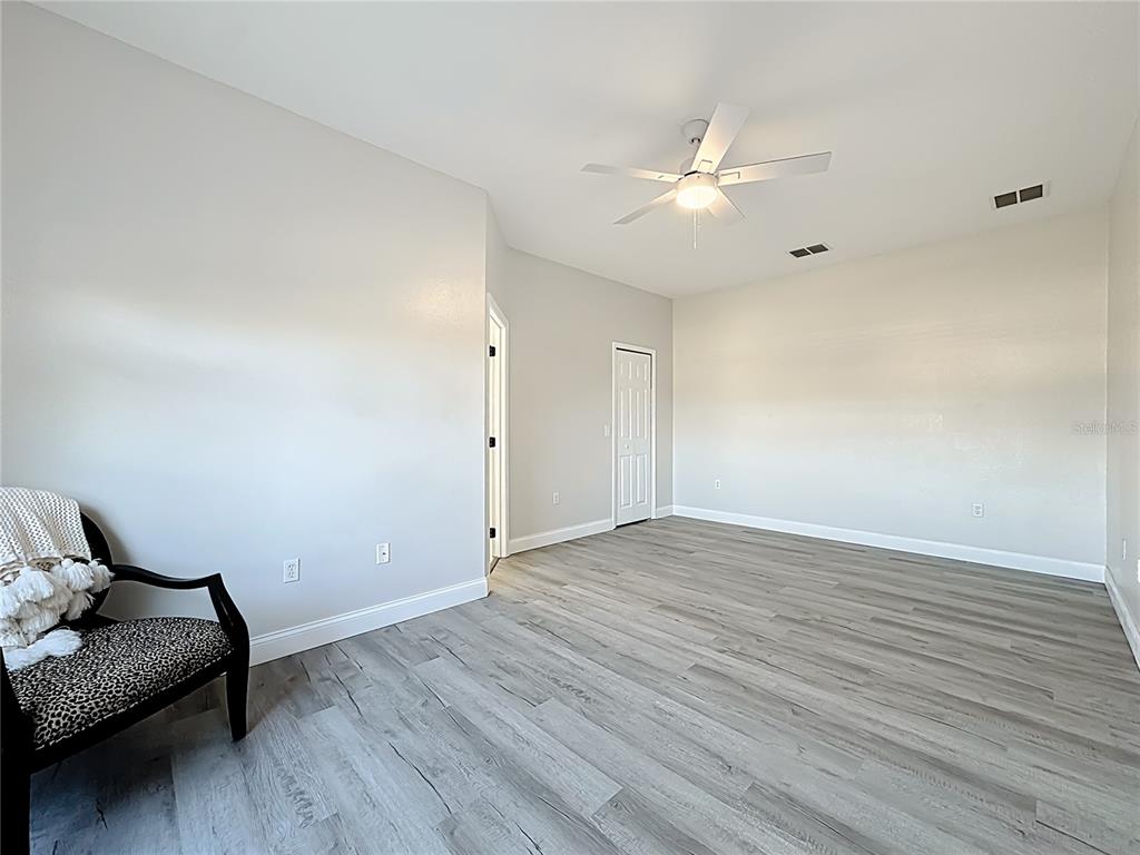 312 Towhee Road Winter Haven, FL 33881 - Photo 25 of 45 a view of an empty room and wooden floor and a ceiling fan