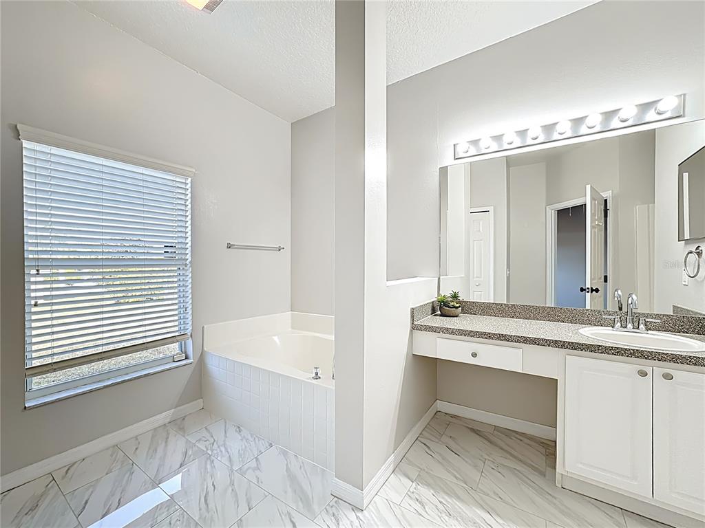 312 Towhee Road Winter Haven, FL 33881 - Photo 28 of 45 a spacious bathroom with a granite countertop sink mirror and a bathtub