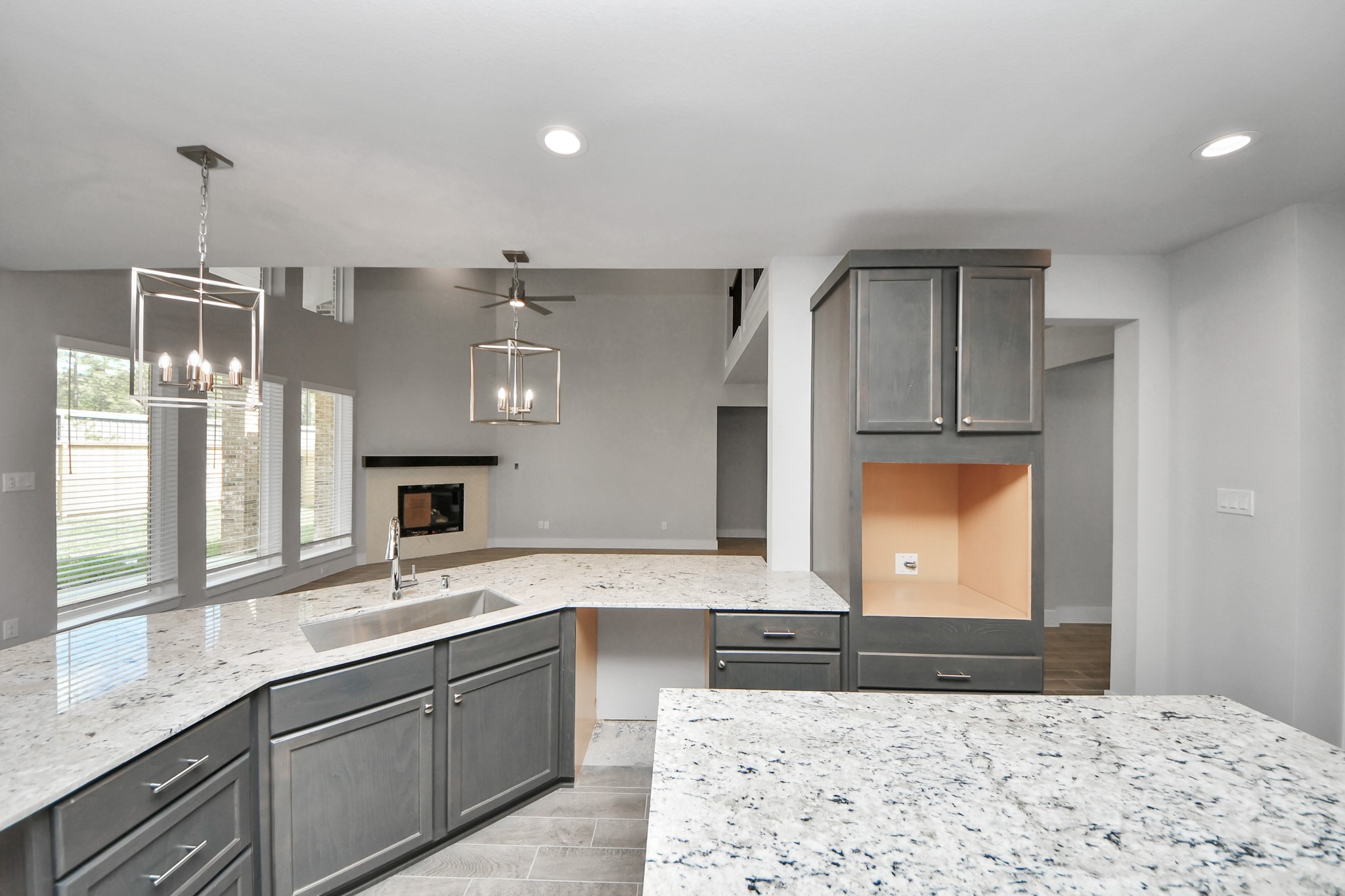 3110 Native Spg Drive Spring, TX 77373 - Photo 10 of 34 This kitchen is truly a chef's dream! This haven Boasts high ceilings, recessed & pendant lighting, stained wood cabinets, granite countertops, stainless steel appliances, a modern tile backsplash. All of this overlooks your expansive family room, creating a perfect space for culinary delights and family gatherings. Sample photo of completed home with similar floor plan. Actual colors and selections may vary.