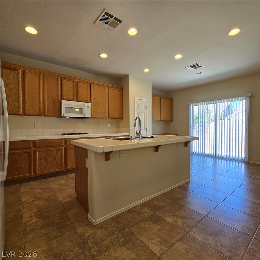 9234 Kingston Road Henderson, NV 89074 - Photo 13 of 38 A well-appointed kitchen featuring a functional island, ample cabinetry, and a bright patio door.