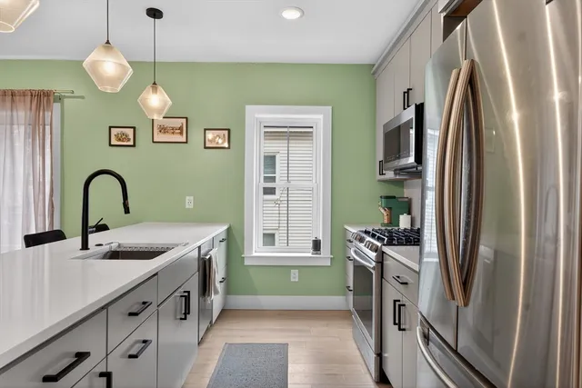 a kitchen with kitchen island a sink stainless steel appliances and cabinets