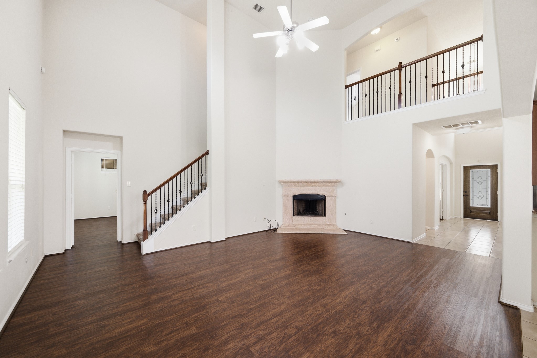 2117 Rushing Spring Drive Pearland, TX 77584 - Photo 10 of 42 Experience the airy elegance of this expansive living area, featuring soaring ceilings, a cozy fireplace, and rich floors that invite relaxation and style.