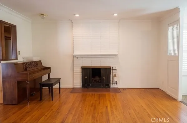 a living room with a fireplace and wooden floor