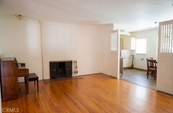 a view of a livingroom with wooden floor and a fireplace