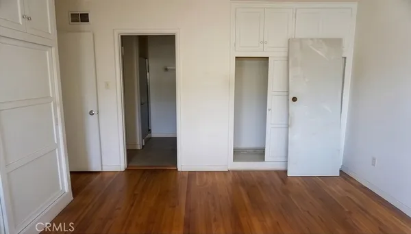 an empty room with wooden floor and closet