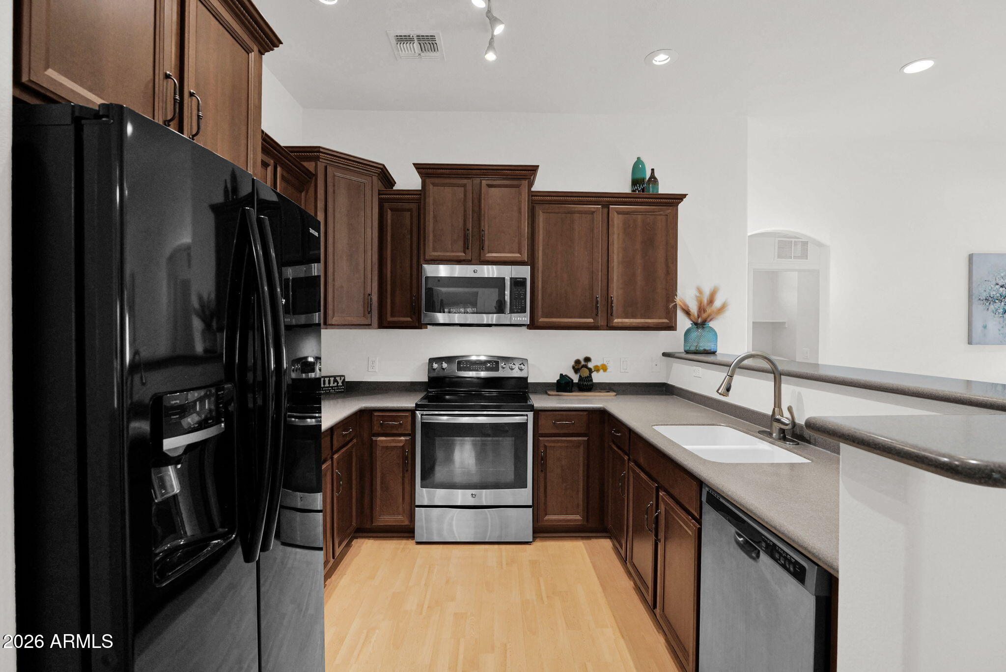 2402 East 5th Street, Unit 1646 Tempe, AZ 85288 - Photo 3 of 37 a kitchen with kitchen island granite countertop stainless steel appliances and wooden cabinets
