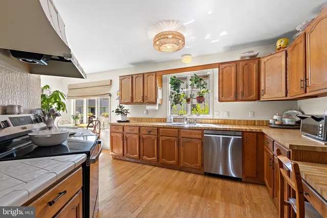 a kitchen with stainless steel appliances granite countertop white cabinets a sink and dishwasher with wooden floor