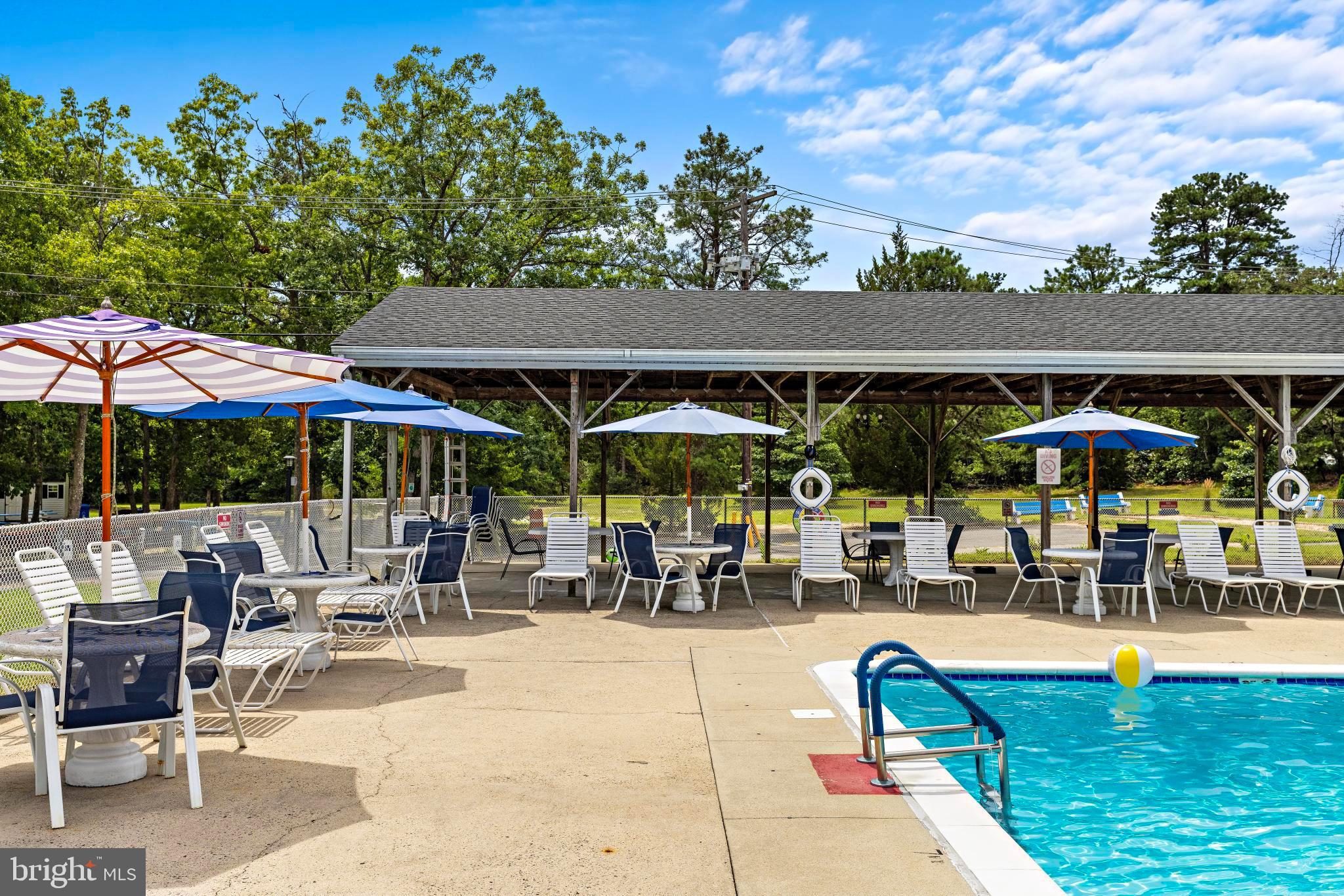 37 Fir Road Manahawkin, NJ 08050 - Photo 36 of 40 a view of patio with chairs and table under an umbrella