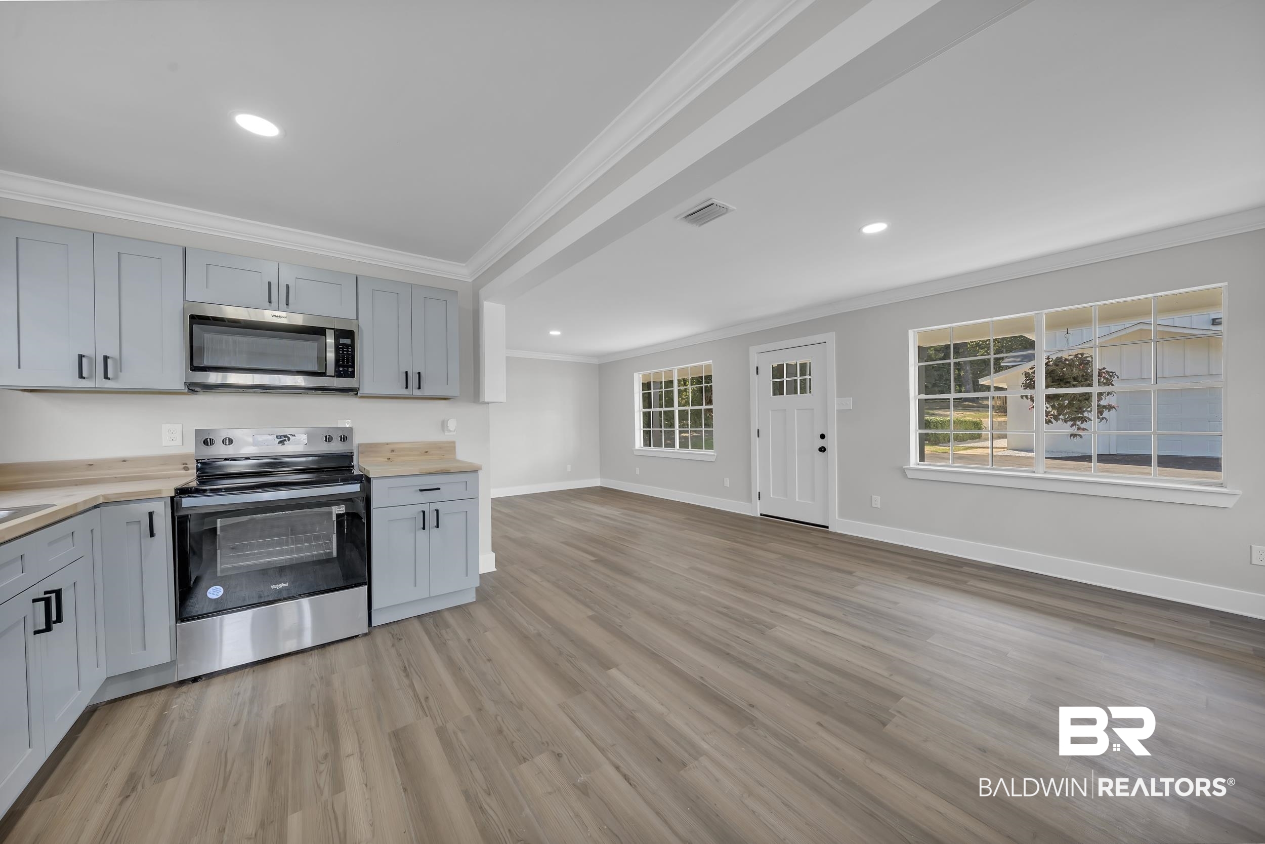 8351 Theodore Dawes Road Theodore, AL 36582 - Photo 34 of 46 Kitchen with appliances with stainless steel finishes, crown molding, gray cabinetry, light wood finished floors, and recessed lighting