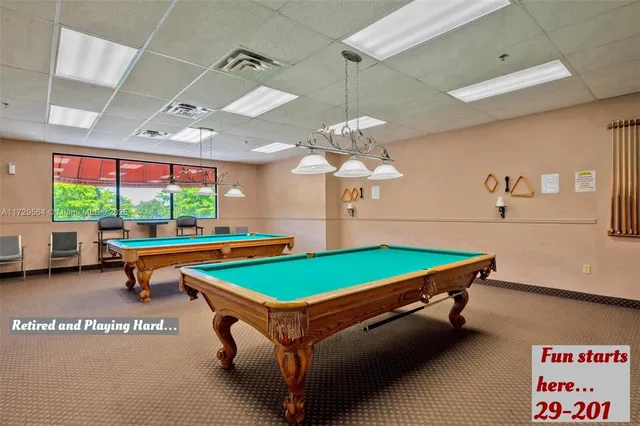a room with pool table and windows
