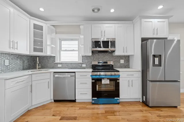 a kitchen with stainless steel appliances granite countertop a stove a refrigerator and a microwave