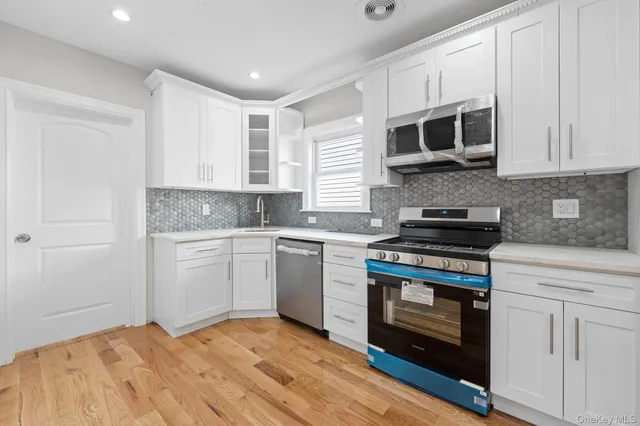 a kitchen with stainless steel appliances granite countertop a stove a sink and a microwave