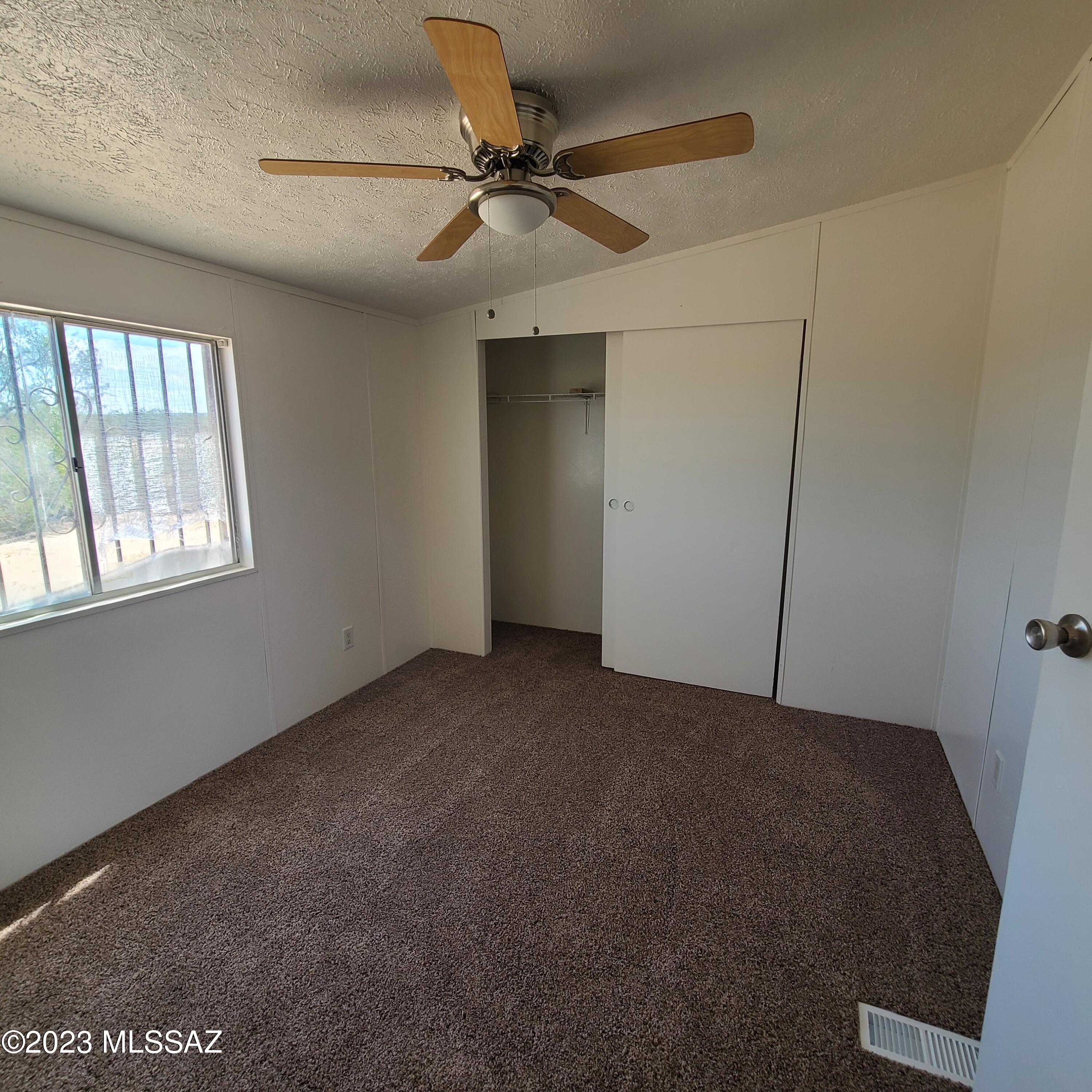 8896 South Marstellar Road Tucson, AZ 85736 - Photo 14 of 39 a view of a livingroom with a ceiling fan and window