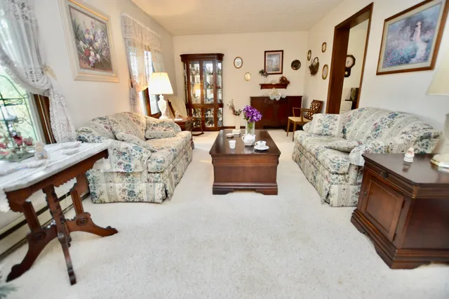 a living room with furniture fireplace and a large window