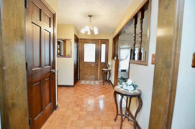 a view of a hallway with furniture and chandelier