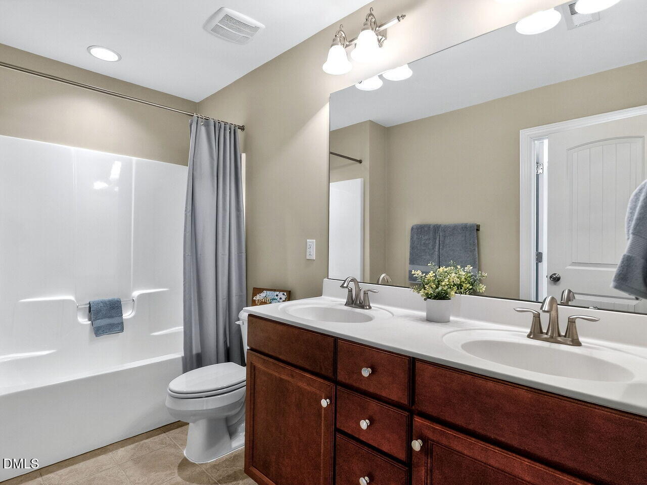 722 Toms Creek Road Cary, NC 27519 - Photo 29 of 42 a bathroom with a double vanity sink a toilet and a large mirror